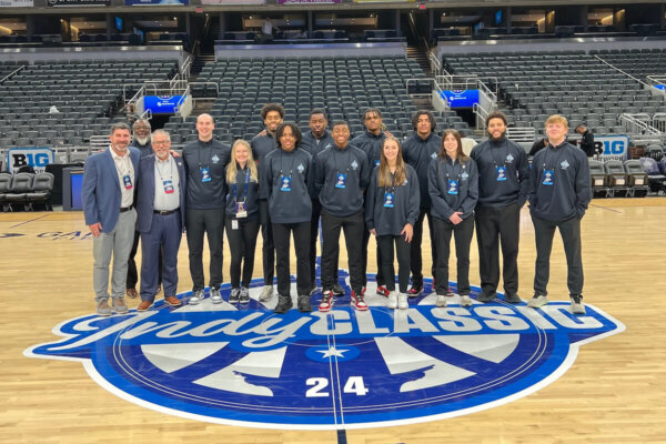 Group photo of Shenandoah University students and staff at midcourt during the Indy Classic in Indianapolis.