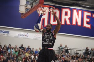 Harlem Globetrotters player Bulldog Mack dunks a basketball.