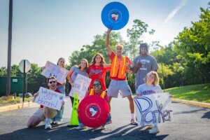 Shenandoah University volunteers hold welcome signs during Move-In Day.