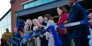 Shenandoah University officials; Cecil Pruitt, Jr.; and members of the Hazel family cut a ribbon to celebrate the opening of Hazel-Pruitt Armory.