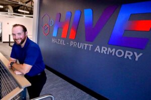 Shenandoah student Bryan McKane inside the Hazel-Pruitt Armory, with the building's logo behind him.