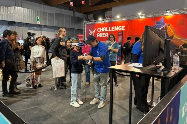 A Shenandoah University esports student helps an attendee at an esports event in Belgium. 