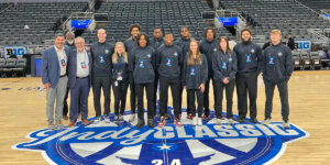 Group photo of Shenandoah University students and staff at midcourt during the Indy Classic in Indianapolis.